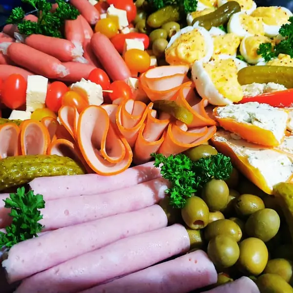 Cold meat platter with sausages, ham rolls, eggs and pickles
