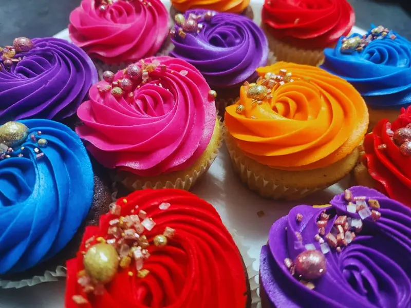 Cupcakes with bright pink, purple, orange and blue swirled icing
