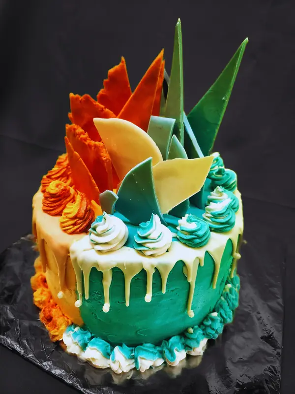 Teal drip cake decorated with orange chocolate shards